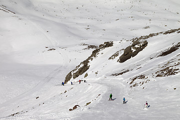 Image showing Snowboarders and skiers on ski slope at sun day