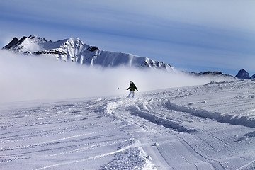 Image showing Snowboarder downhill on off-piste slope with newly-fallen snow