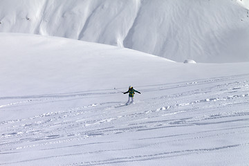 Image showing Snowboarder downhill on off piste slope with newly-fallen snow