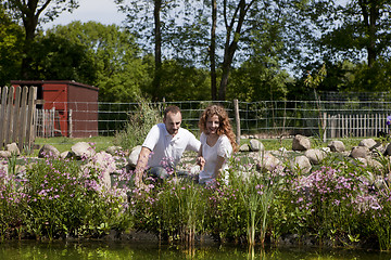 Image showing couple on pink flowered garden pond, ehepaar am gartenteich pink