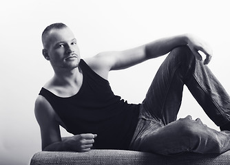Image showing young athletic man lying on a sofa bw