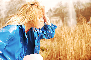 Image showing Young Woman wearing blue rain coat