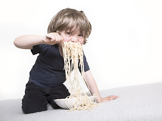 Image showing Child eating spaghetti joyfully