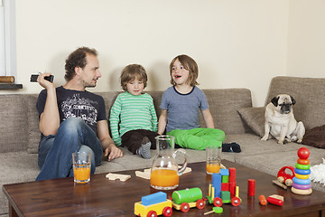 Image showing father with sons and dog on sofa