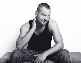 Image showing young man sitting with hand on his head bw