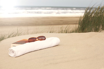 Image showing Book sunglasses  towel on a beach