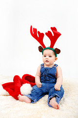 Image showing Child girl with Christmas santa hat and reindeer antlers