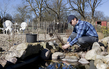 Image showing Man cleans creek