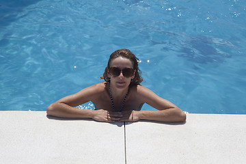 Image showing woman with sunglasses bathes in pool