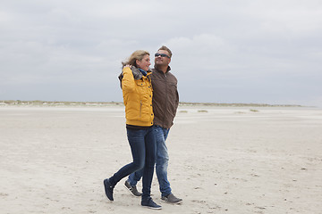 Image showing Couple goes on a sandy beach in autumn