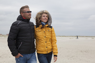 Image showing Couple goes for a walk on the beach in autumn