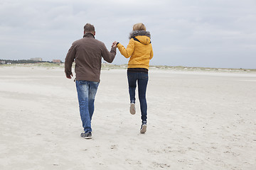 Image showing Couple on the sandy beach in autumn