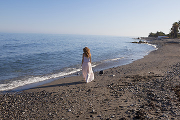 Image showing young woman walking on the beach