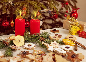 Image showing many colorful biscuits and candles in front of christmas tree