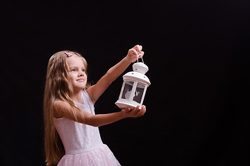 Image showing Five-year girl shines candlestick into the distance