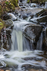 Image showing Small waterfall with icicles and ice close up, spring.