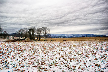 Image showing snow covered farm field with mountains in background