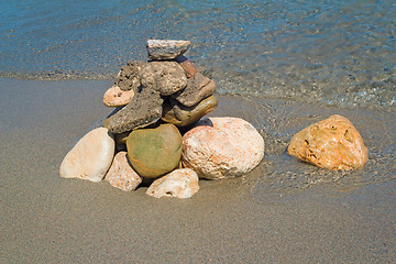 Image showing Small sea stones on the seashore, covered with a sea wave.