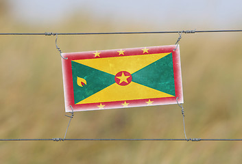 Image showing Border fence - Old plastic sign with a flag