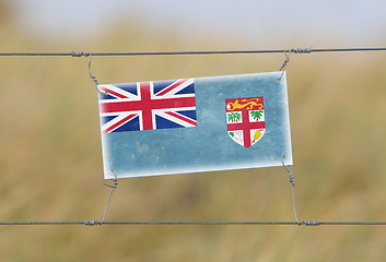 Image showing Border fence - Old plastic sign with a flag