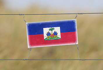 Image showing Border fence - Old plastic sign with a flag