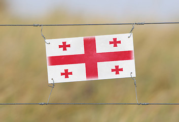 Image showing Border fence - Old plastic sign with a flag