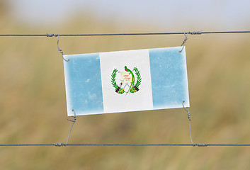 Image showing Border fence - Old plastic sign with a flag