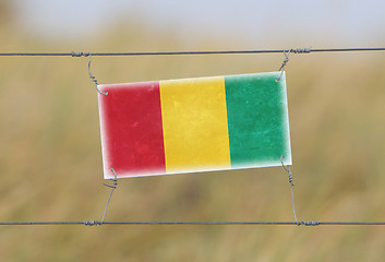 Image showing Border fence - Old plastic sign with a flag