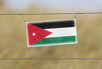 Image showing Border fence - Old plastic sign with a flag