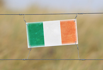 Image showing Border fence - Old plastic sign with a flag