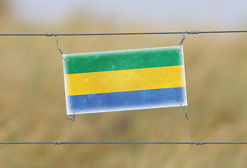 Image showing Border fence - Old plastic sign with a flag