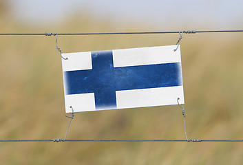 Image showing Border fence - Old plastic sign with a flag