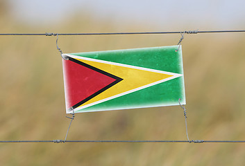 Image showing Border fence - Old plastic sign with a flag