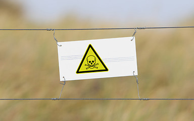 Image showing Border fence - Old plastic sign with a flag