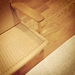Image showing Rattan chair and rug on wooden floor