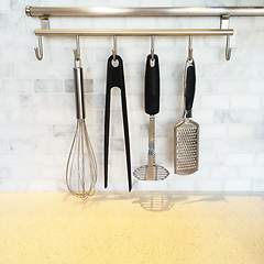 Image showing Kitchen utensils on a metal wall rail