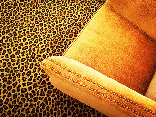 Image showing Orange velvet armchair on leopard carpet