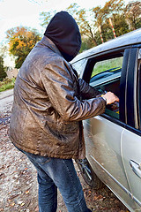 Image showing Hooligan breaking into car