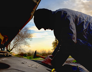 Image showing Hooligan breaking into car