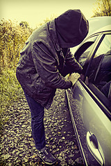 Image showing Hooligan breaking into car