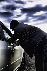 Image showing Hooligan breaking into car