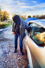 Image showing Hooligan breaking into car