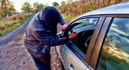 Image showing Hooligan breaking into car