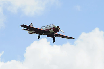 Image showing The small plane flies against clouds.