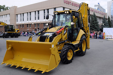 Image showing The yellow bulldozer is on the square in the city.