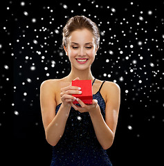 Image showing smiling woman holding red gift box