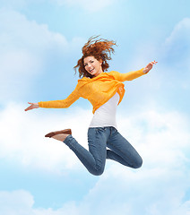 Image showing smiling young woman jumping high in air