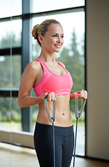 Image showing smiling woman with expander in gym