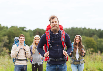 Image showing group of smiling friends with backpacks hiking