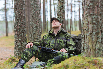 Image showing soldier or hunter with gun sleeping in forest